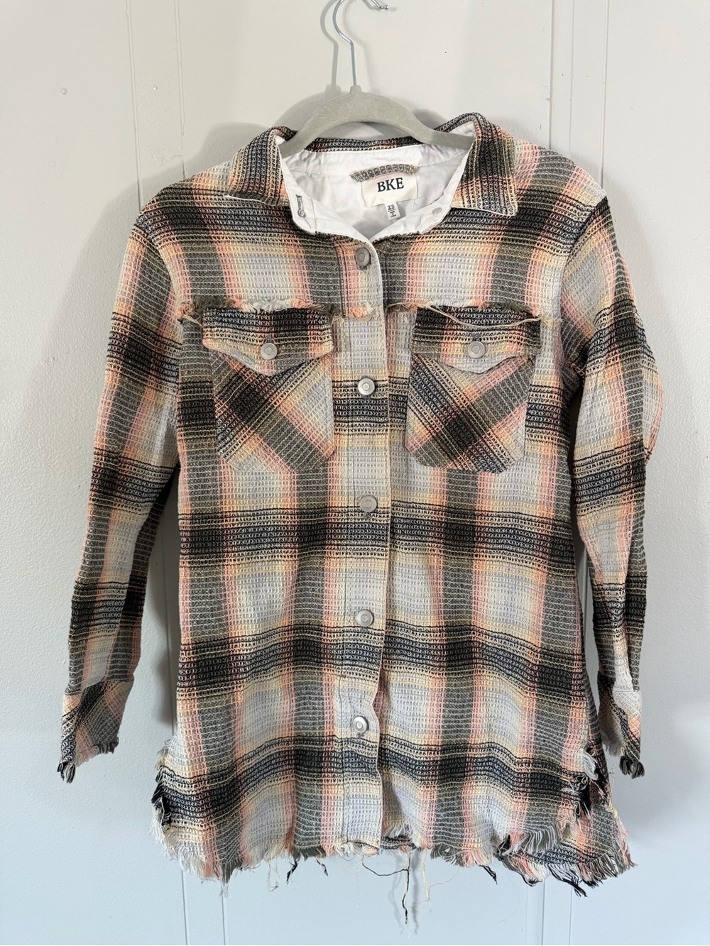 BKE Textured Shacket in a plaid button-down design with frayed hem details.